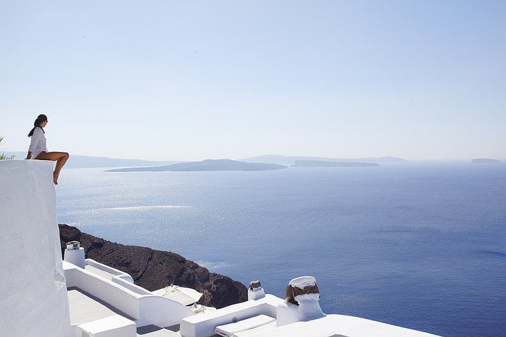 Woman sitting on top of the Kirini Santorini hotel